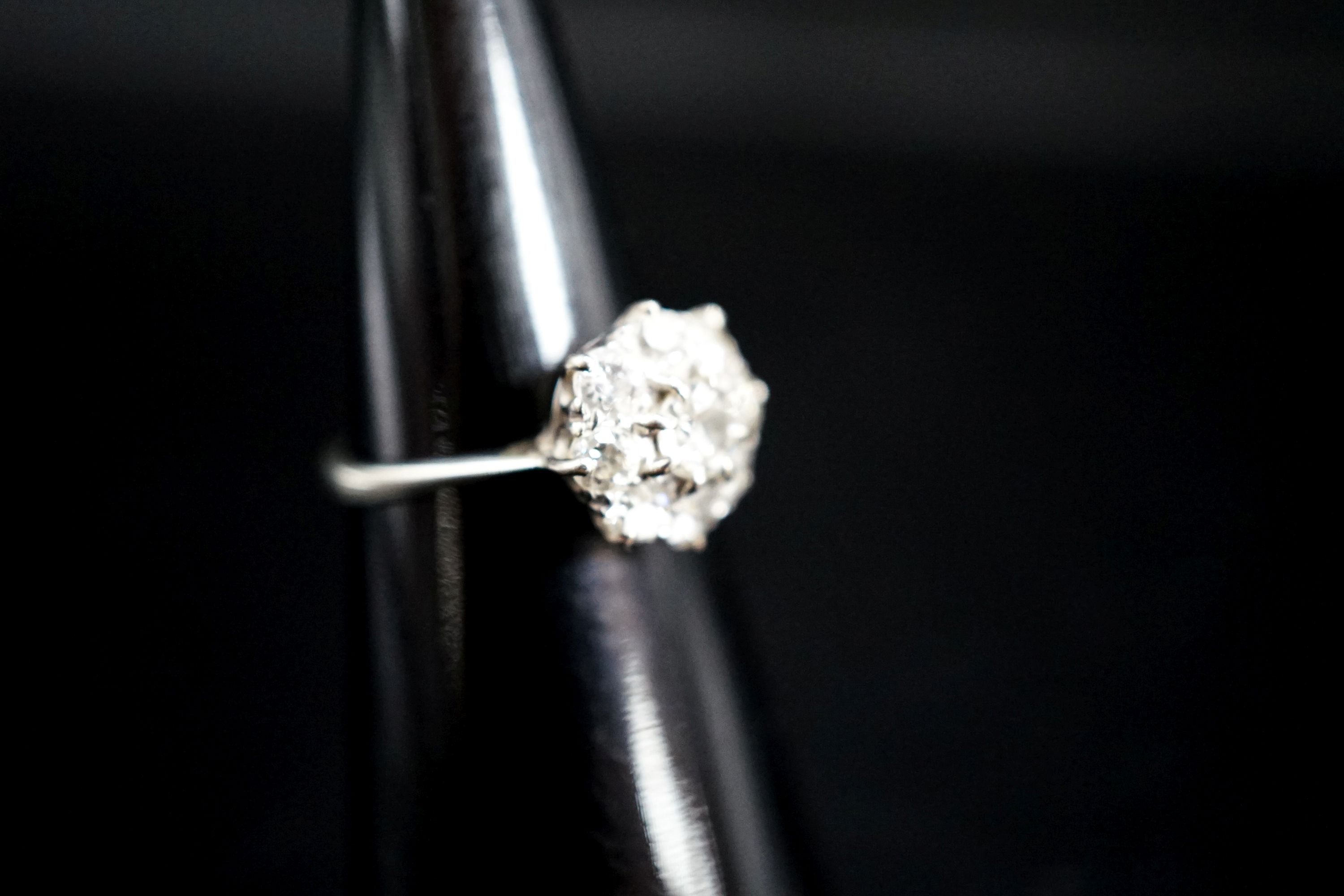 A white metal and diamond cluster ring, size J, gross 2 grams.